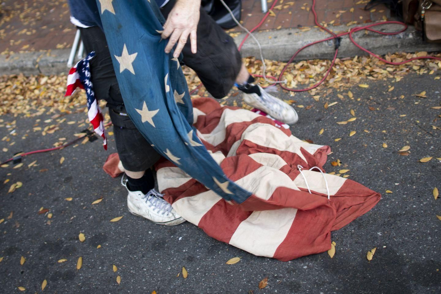 A supporter of President Trump unfurled an American flag while demonstrating Tuesday outside of a building where votes were being counted in Philadelphia (Photo: MARK MAKELA/GETTY)