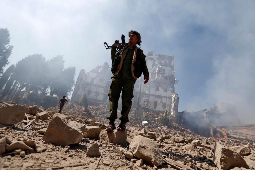 Huthi rebel fighters inspect the damage after a reported air strike carried out by the Saudi-led coalition targeted the presidential palace in the Yemeni capital Sanaa on December 5, 2017. Saudi-led warplanes pounded the rebel-held capital before dawn after the rebels killed former president Ali Abdullah Saleh as he fled the city following the collapse of their uneasy alliance, residents said. (Photo credit should read MOHAMMED HUWAIS/AFP via Getty Images).
