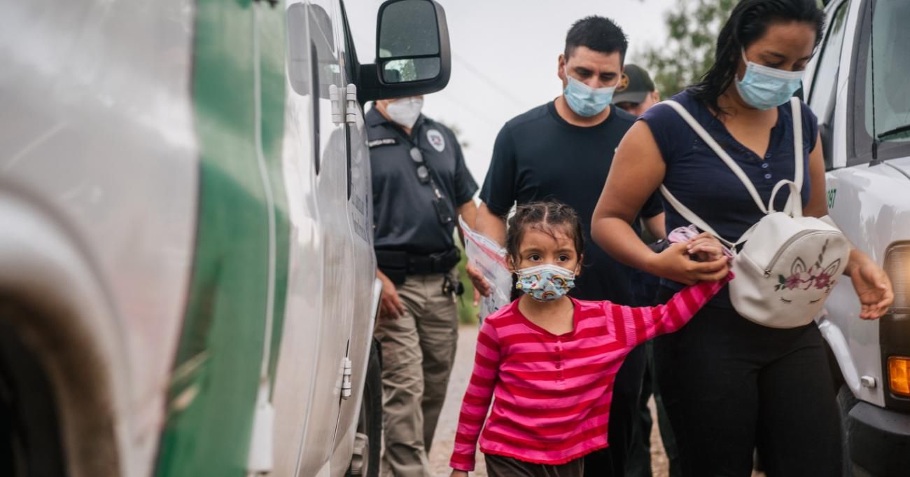 A family is taken to an immigration processing center after crossing the U.S.-Mexico border.