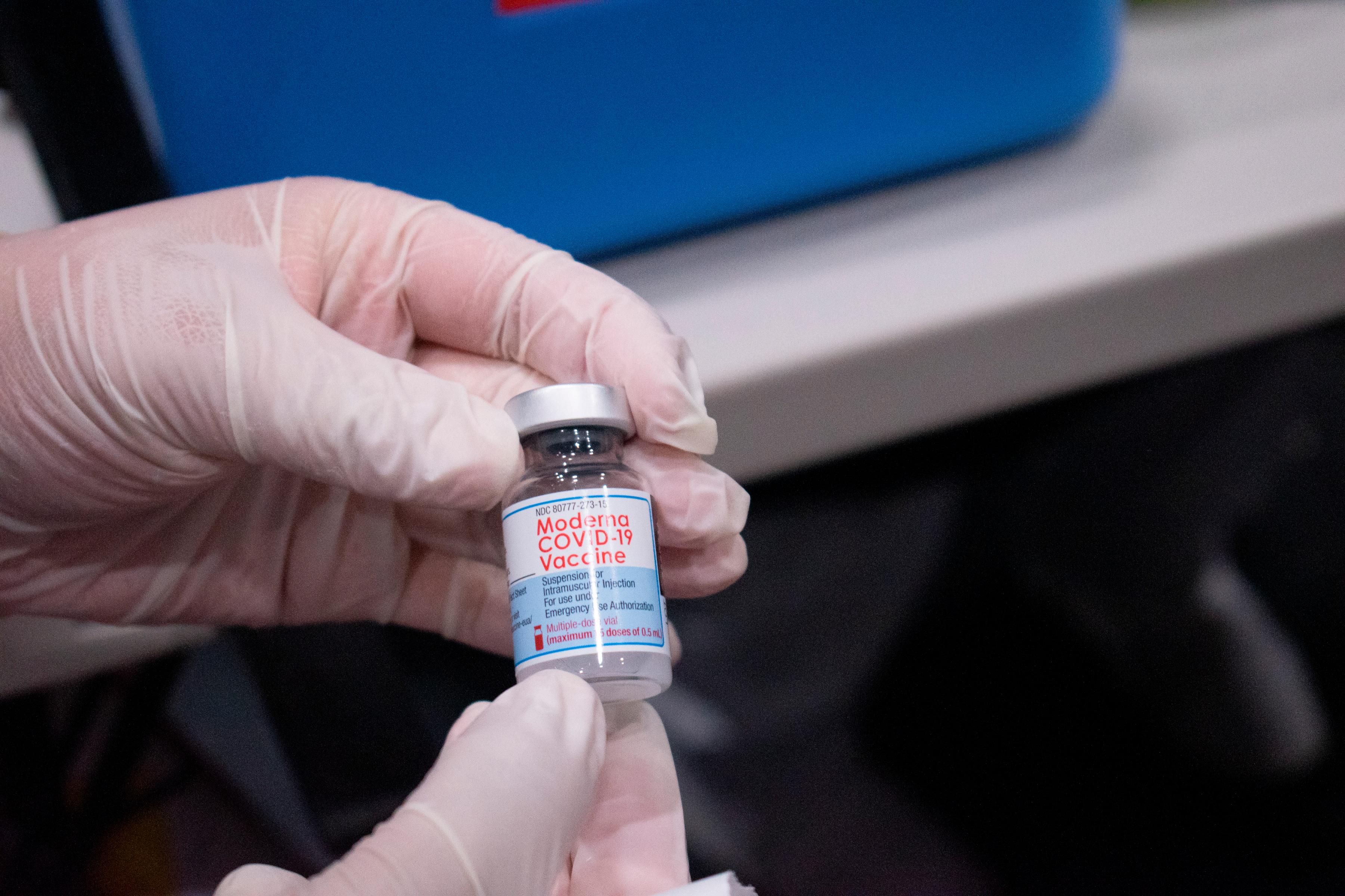 A nurse holds a vial of the Moderna vaccine