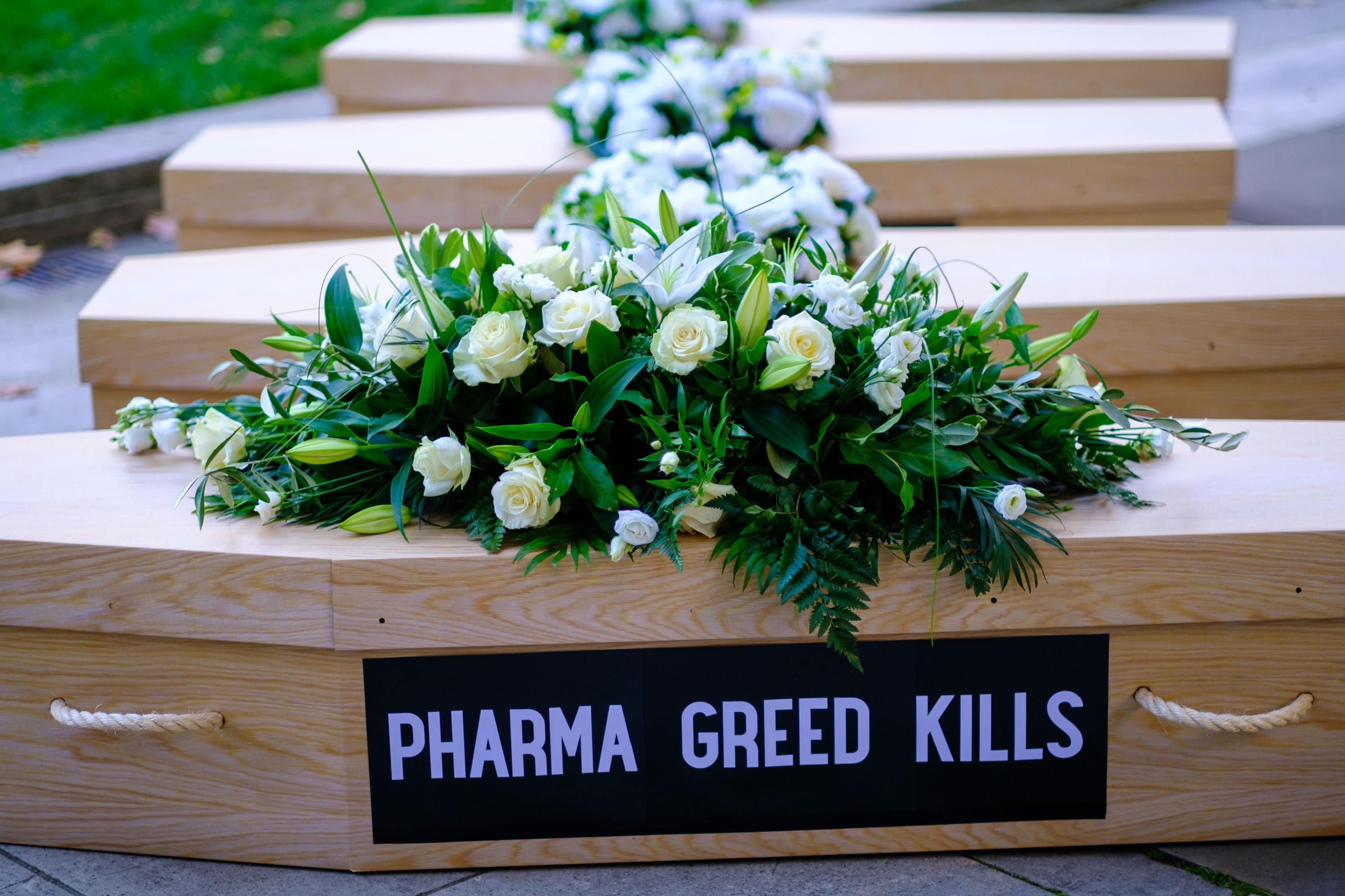 Protesters attached a "pharma greed kills" sign to a mock coffin