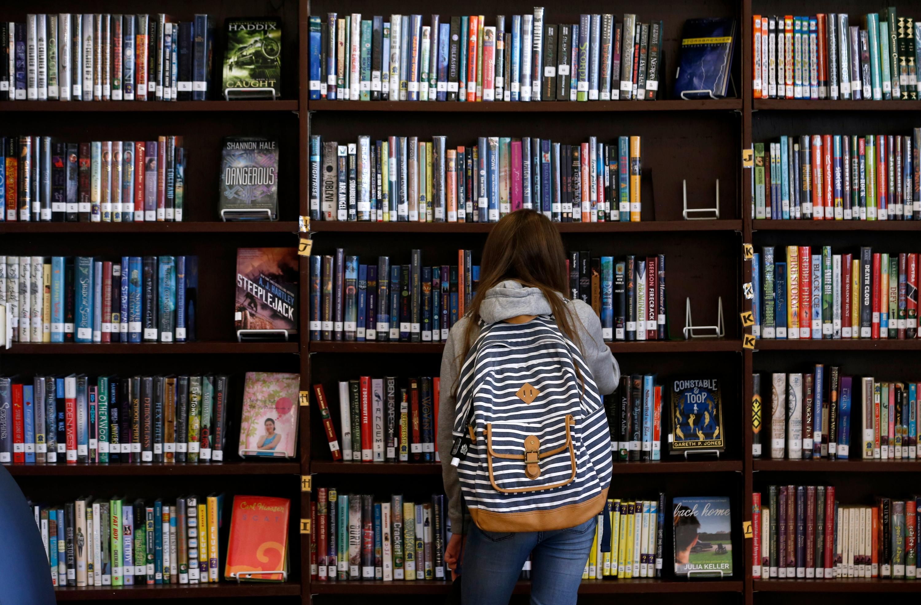 A child looks at books in a school library