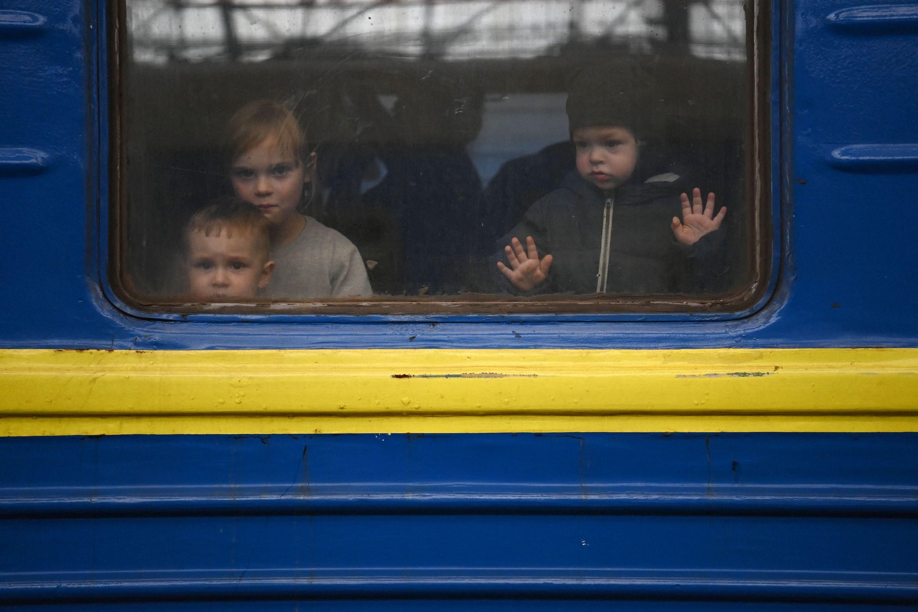Children look out from a carriage window as a train prepares to depart from a station in Lviv, western Ukraine, en route to the town of Uzhhorod near the border with Slovakia, on March 3, 2022. (Photo: Daniel Leal/AFP via Getty Images)
