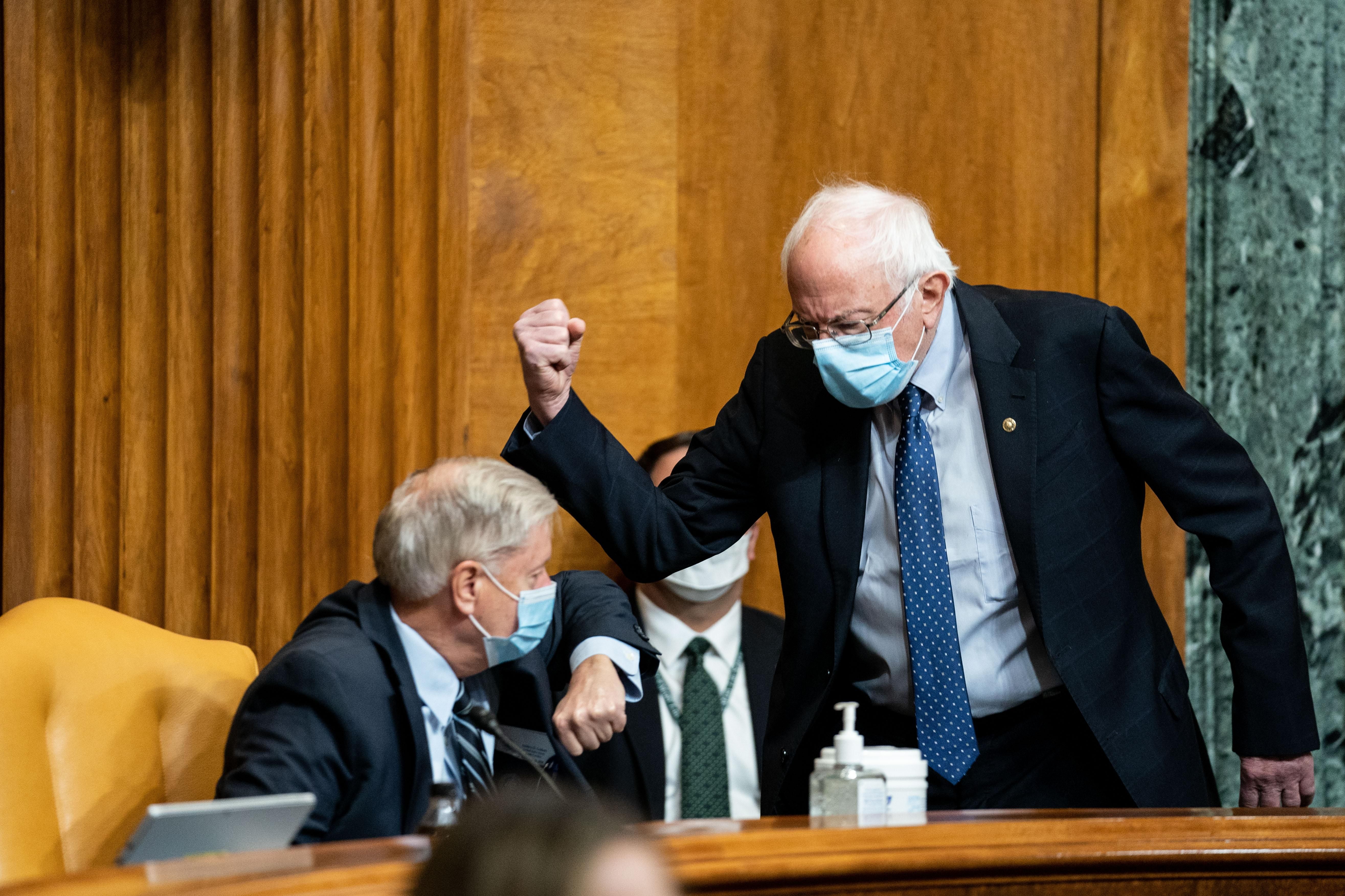 Senate Budget Committee Chairman Bernie Sanders (I-Vt.) and ranking member Sen. Lindsey Graham (R-S.C.) bump elbows prior to a hearing in Washington, D.C. on February 10, 2021.