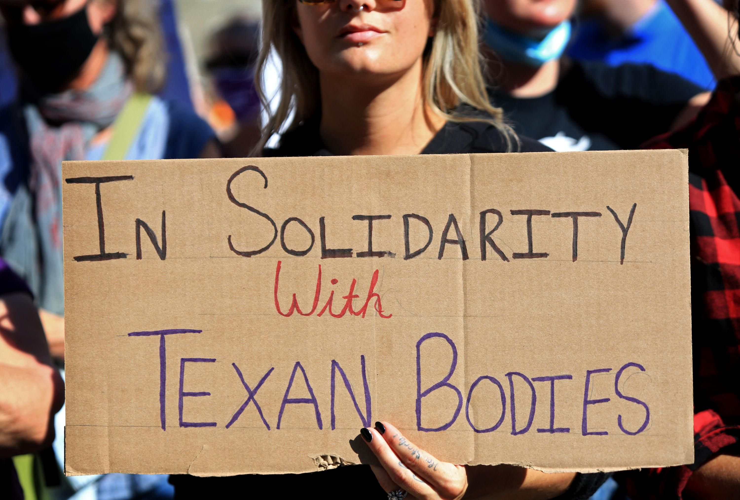 Sign says in solidarity with Texan bodies