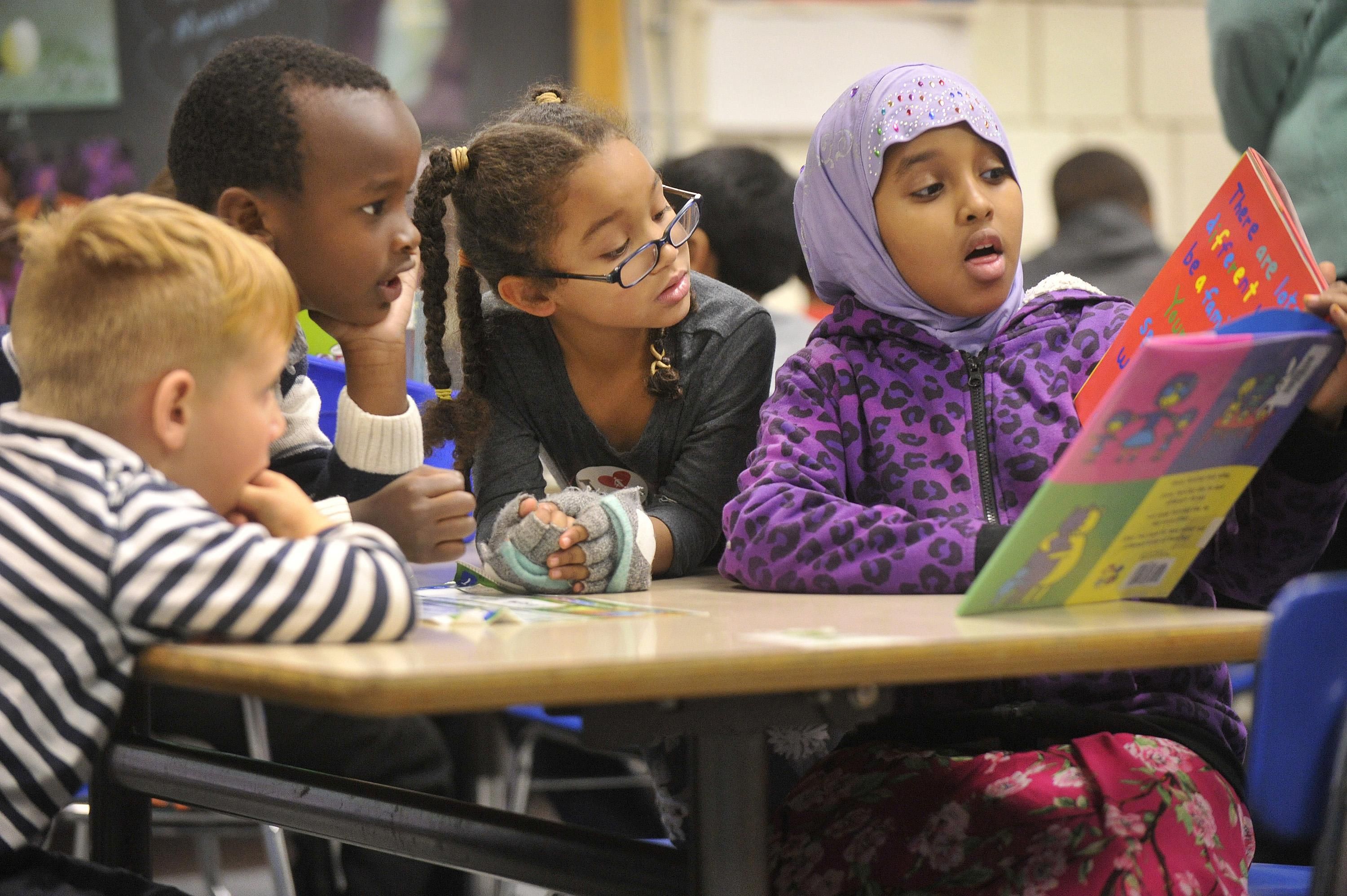 Nine-year-old Nasra Omar reads a book to 1st graders at Riverton Elementary School. The school's mentoring Civil Rights Team, made up of 4th and 5th graders, read books to kindergartners and first graders about civil rights and anti-bias themes in Portland, Maine. (Photo: John Ewing/Portland Portland Press Herald via Getty Images)