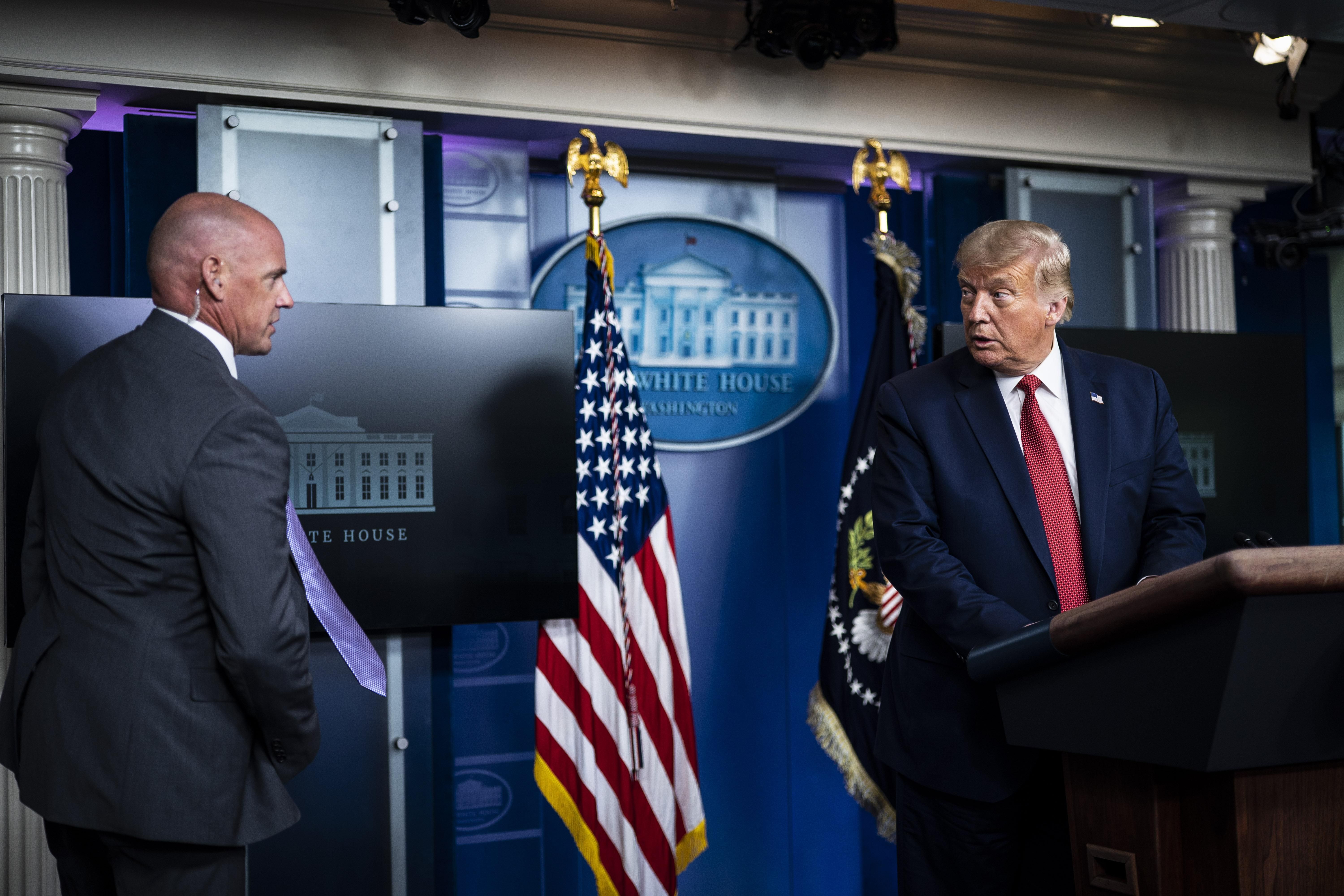 A member of the Secret Service speaks to then-President Donald Trump at the White House on August 10, 2020 in Washington, D.C. 