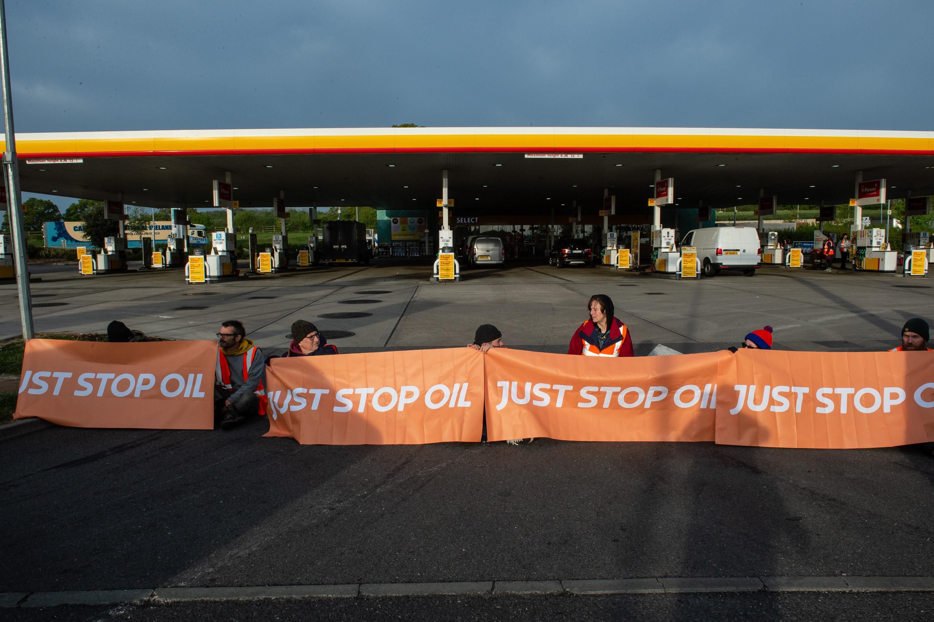 Activists from Just Stop Oil block the entrance to a Shell gas station on April 28, 2022 in Cobham, England.