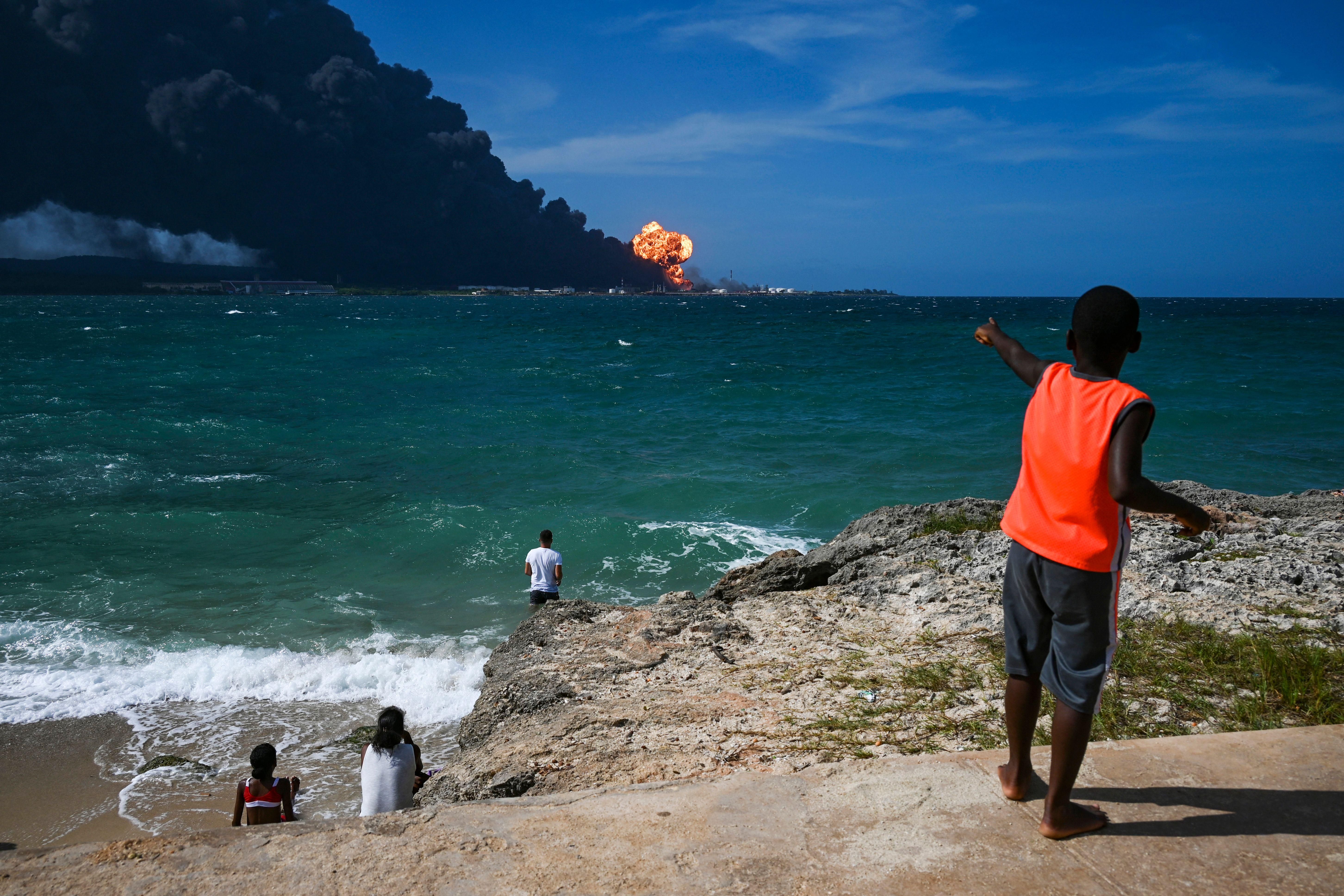 Cubans watch as a massive fire spreads at a fuel depot in Matanzas on August 8, 2022.