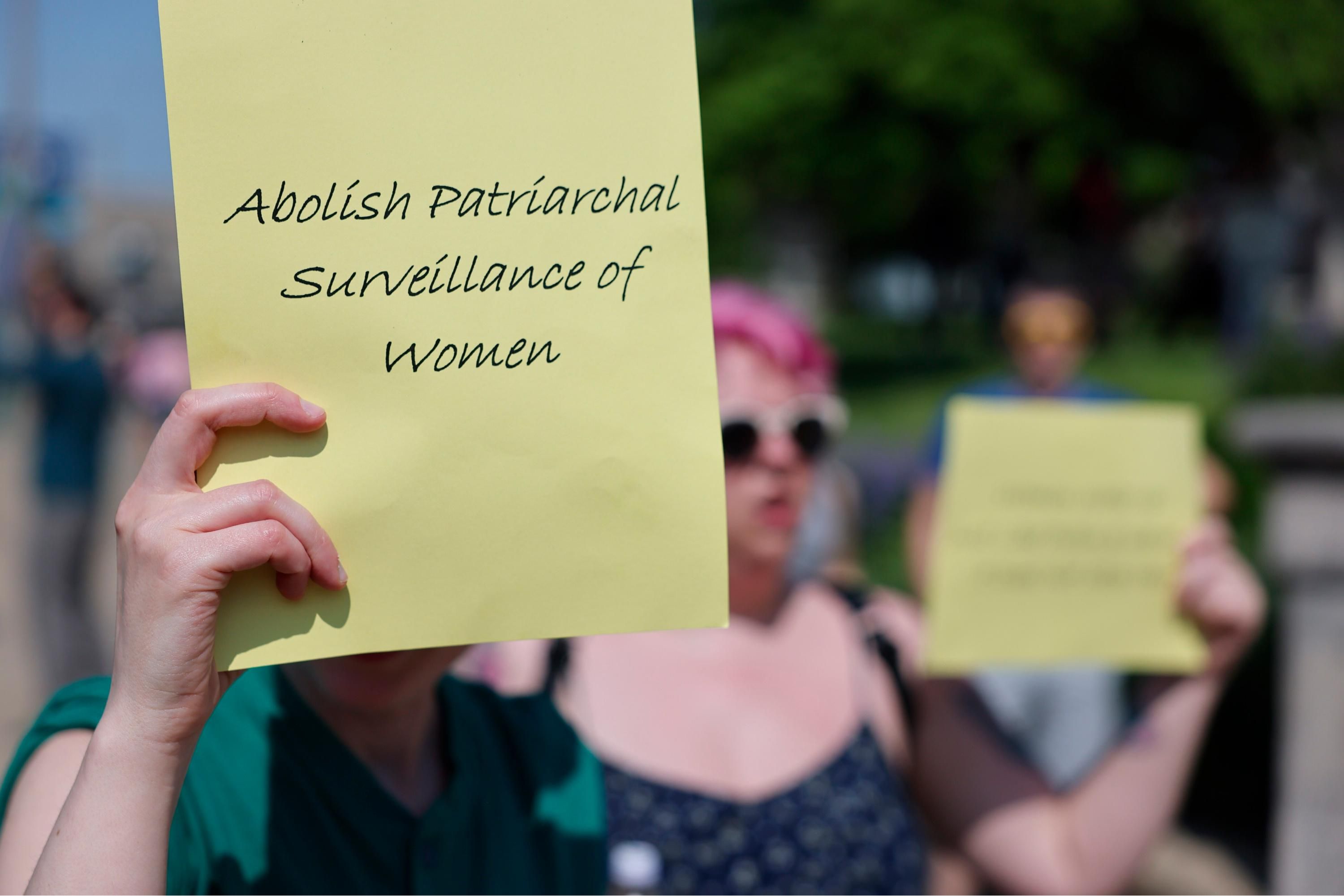 Abortion rights protest, sign readig "abolish patriarchal surveillance of women"