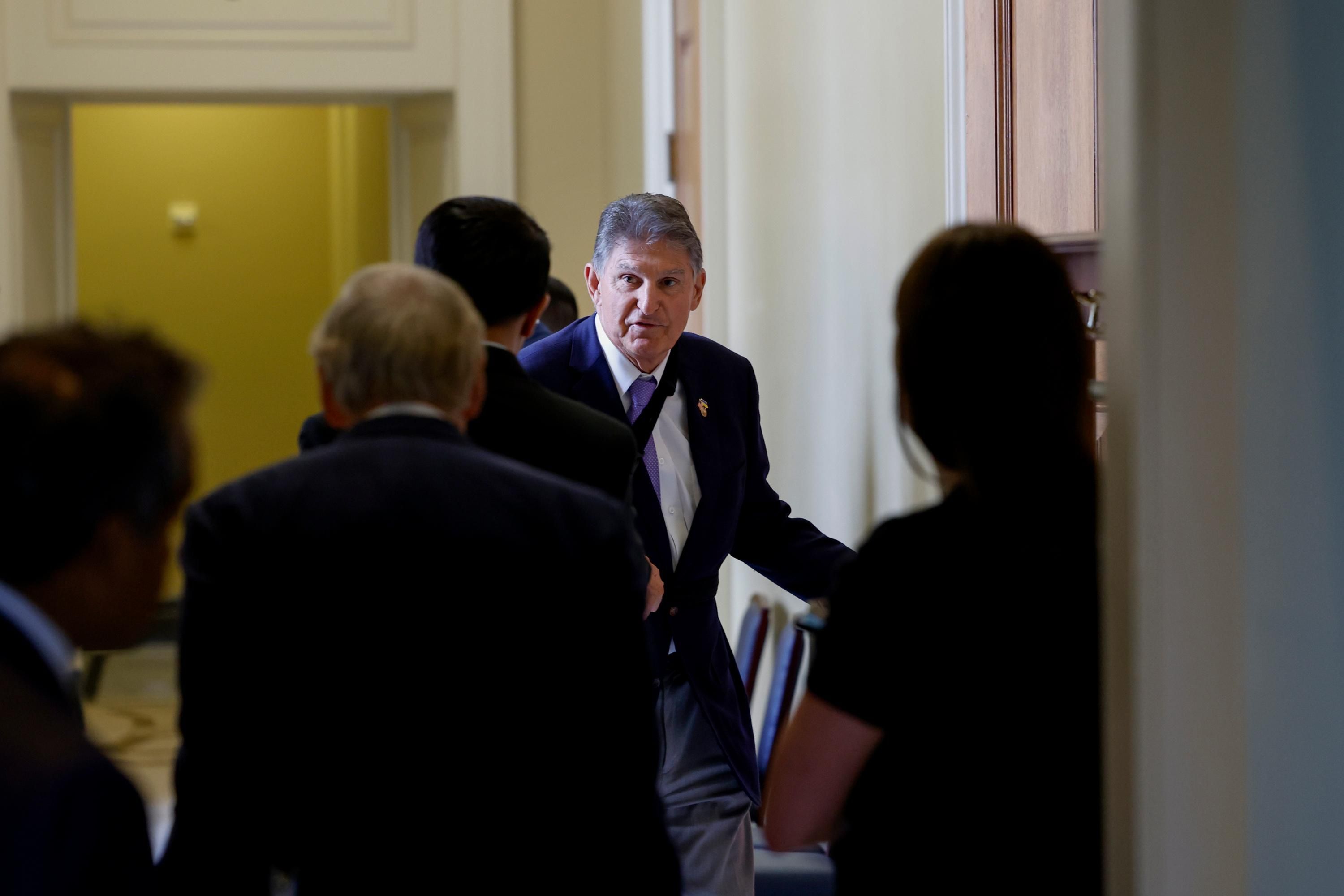 Sen. Joe Manchin walks to a policy lunch