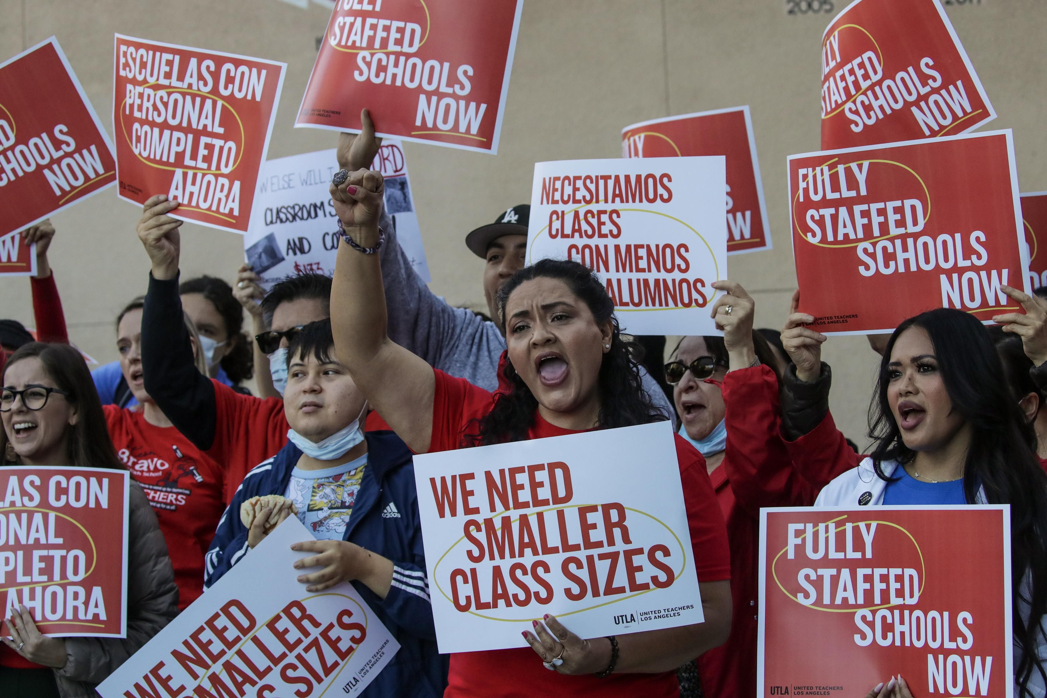 Teachers union members holding signs that read "We Need Smaller Class Sizes" and "Fully Staffed Schools Now"
