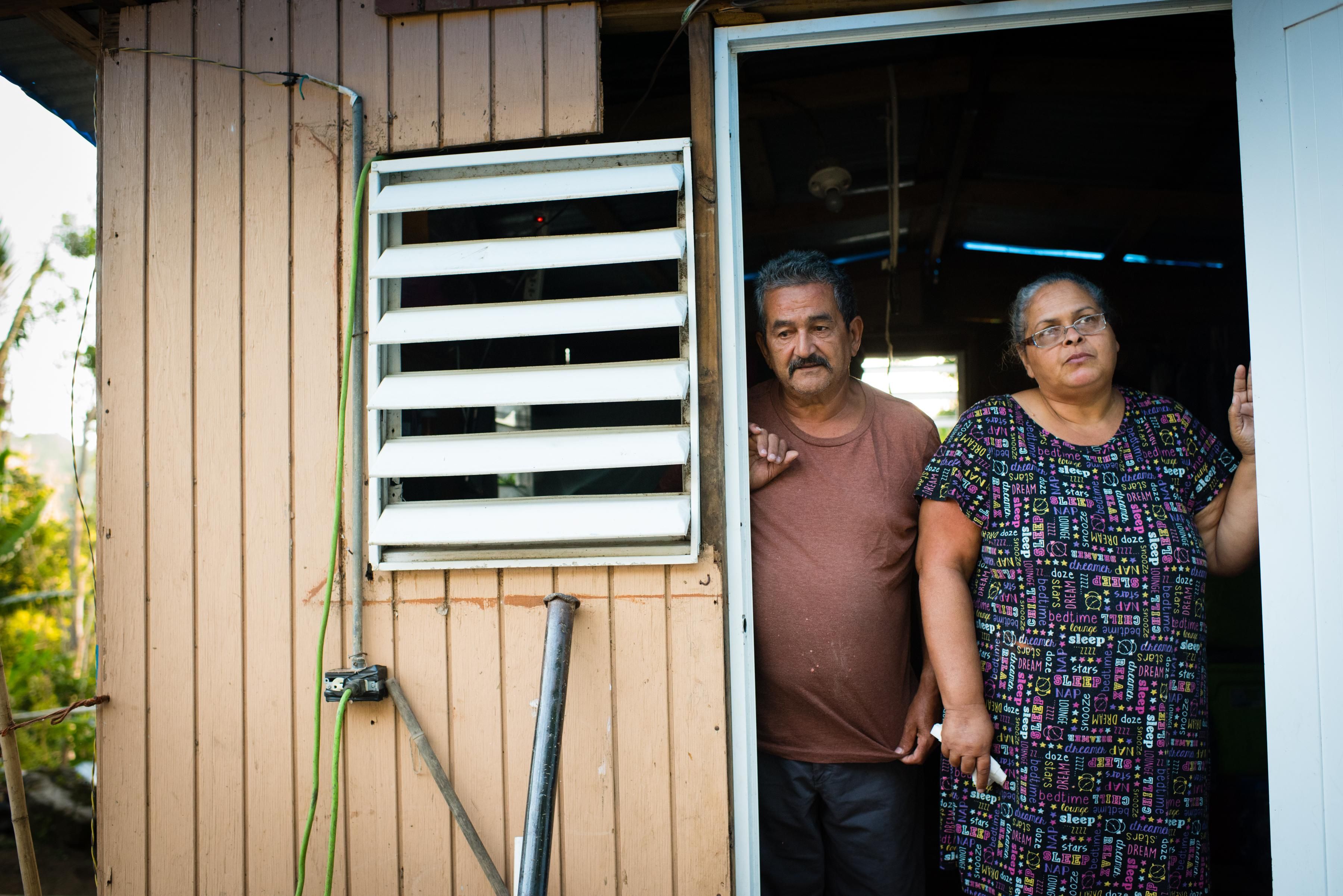 Carlos Fernandez and his wife, Ivette Garcia, stand in the doorway of their temporary house in Villalba, Puerto Rico on August 27, 2018, one year after Hurricane Maria destroyed their home.