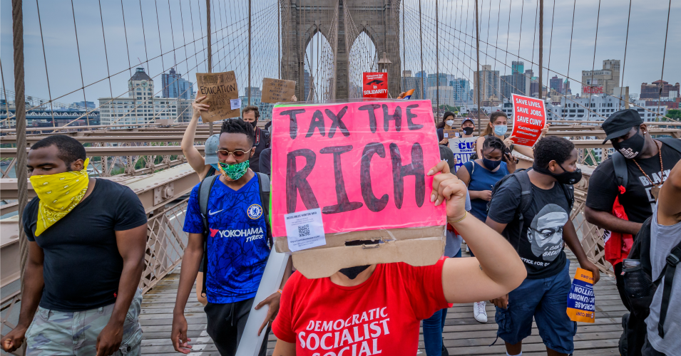 A demonstrator holds a "Tax the Rich" sign during a protest in New York on June 27, 2020.