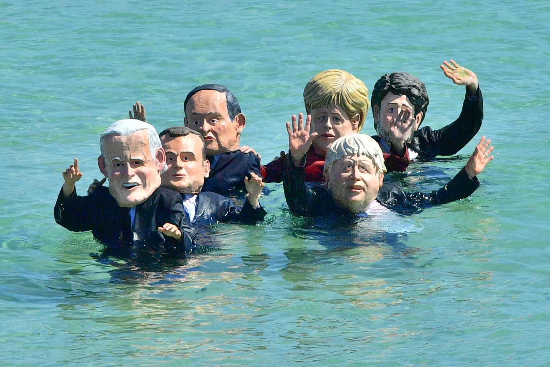 Extinction Rebellion protesters, wearing masks of G7 leaders in the sea in St Ives, during the G7 summit in Cornwall on Sunday June 13, 2021. (Photo:B